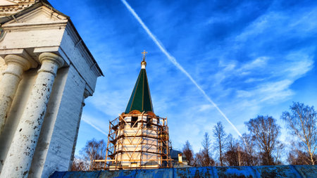 The dome of the Orthodox church with a cross, big colums and blue sky with white clouds on a background in spring dayの写真素材