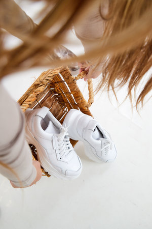 White women sneakers in the studio on white background. Fashion shooting for catalog or store indoorsの写真素材