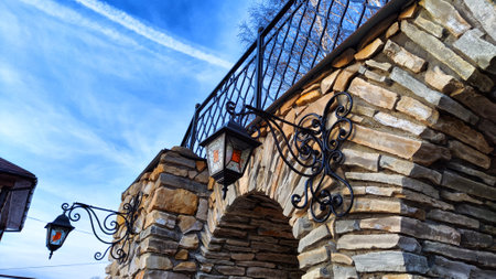 Part of the decoration of stone facade of building with vintage lantern on blue sky backgroundの写真素材