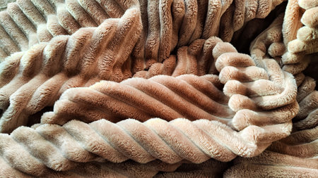 Closeup photo of soft, fluffy sleeping beige blanket or plaid. Crumpled fabric. Abstract background and texture with frame. Partial focusの写真素材