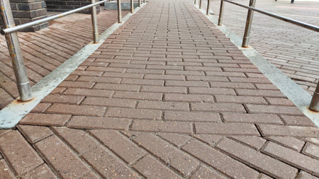 Background and texture of tiles on the sidewalk. The sidewalk on street is made of pieces of tile or brick. Gray color outdoors.の写真素材