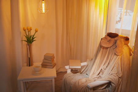 Living room with armchair, window, fabric curtains, bouquet of tulips in a vase and gentle light and lighting. Loft style interior. background and location for photoshootの写真素材