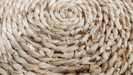 Round braided natural straw table mat texture as a background. Full frame of tightly woven straw pattern. Ppace, copy space for text, for a backgroundの写真素材