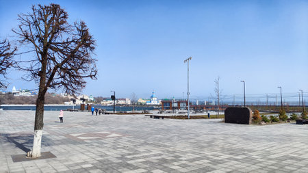 Cheboksary, RUSSIA - April 05, 2023: A large city square with small buildings in the background, snow, snowdrifts in the center, houses in the background and a blue sky on winter or spring sunny dayのeditorial素材