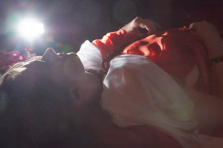 Beautiful European girl looking like Arab woman in red room with rich fabrics and carpets in sultan harem. Photo shoot of an oriental style odalisque. A model poses in sari as indian woman in indiaの写真素材