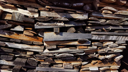 Woodpile with wooden boards, firewood. Abstract background, texture, frame and copy space. Pile and pile of old wood for construction and burning on fire, heatingの写真素材