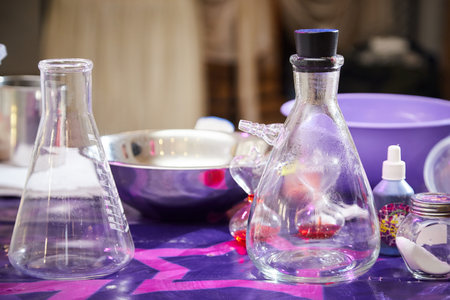 Retort, a glass jar, a phial on a table with a purple surface. Preparation for a chemical experiment in the laboratoryの写真素材