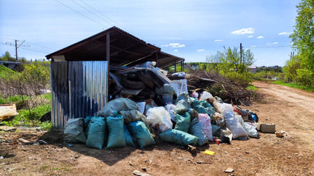 Kirov, Russia - May 15, 2023: Garbage and landfill in nature among the grass on sunny spring or summer day. Poor ecology and pollution of the environment by humansのeditorial素材