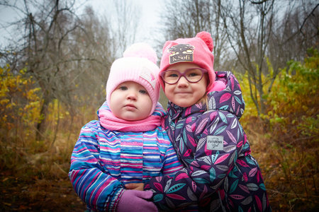 Kirov, Russia - October 23, 2022: Funny young small toddler children walking in beautiful autumn park on cold fall day. Kids having funのeditorial素材