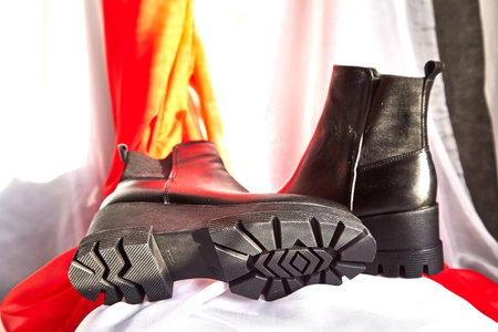 Female winter, autumn or spring black leather shoes in studio. Fashionable modern photography for...