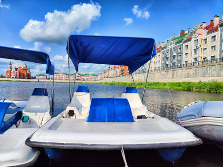 Plastic catamarans are in row on the water surface of city pond. Summer vacation on the water....