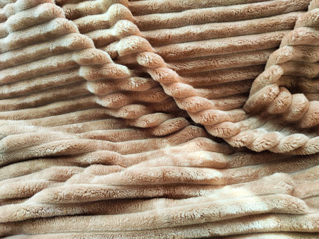 Closeup soft, fluffy sleeping beige blanket or plaid. Crumpled fabric. Abstract background, texture...