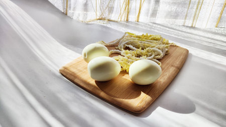 Chopped Peking cabbage and peeled eggs on cutting board as background. Cooking a healthy...