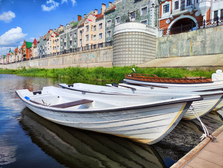 Harbor with wooden boats in city. Embankment of the resort town. Sunny summer day and water landscape in summerの写真素材