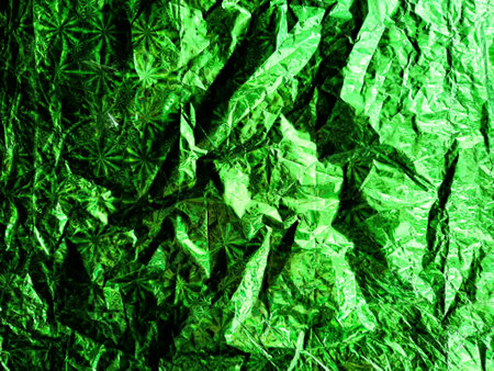 Beautiful abstract background and texture of crumpled aluminum foil in green color. Pattern, place for text and copy spaceの写真素材