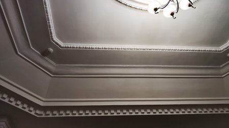 The architectural element is square geometric stucco on a white ceiling. Background, texture, structure, frame, place for text and copy spaceの写真素材