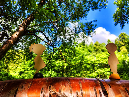 Wooden figurines of boy and a girl, men and women against the backdrop of nature. Teenagers on date. The concept of dating, love, friendship, meeting, and relationships. Blur and partial focusの写真素材