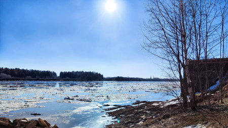 Spring landscape with water and ice on river and blue sky in background in sunny day. Ice drift and...
