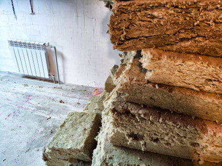 Pieces of mineral wool on construction site in an unfinished house. Spongy and rough abstract...