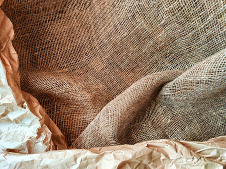 Heavily crumpled textured kraft paper and burlap jute fabric. Soft and hard texture. Abstract background, frame, place for text, copy spaceの写真素材