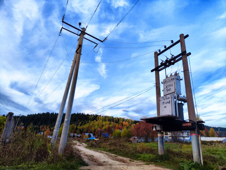 Old power poles and the sky with clouds in the background. Electric lines, towers, wires in...