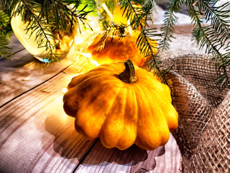 Festive decoration with bouquet and branches of spruce, bright glowing garlands, oranges on wooden background. Decor for Christmas and New Year. Abstract texture, frame, place for text and copy spaceの写真素材