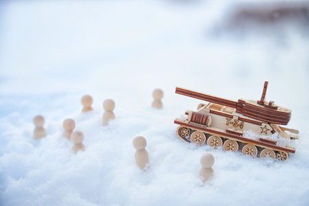 Wooden toy Russian tank T-34 and little men in the snow. Russia and Ukraine are at war in winter. Encirclement, retreat, attack, victoryの写真素材