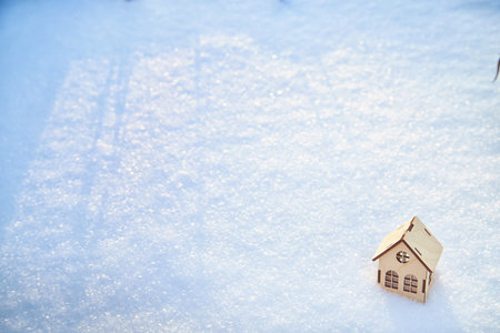 Wooden toy house on snow, natural abstract background. winter season concept. symbol of cozy, loving family home. construction, sales, rental concept. Christmas and new year holidays. copy spaceの写真素材