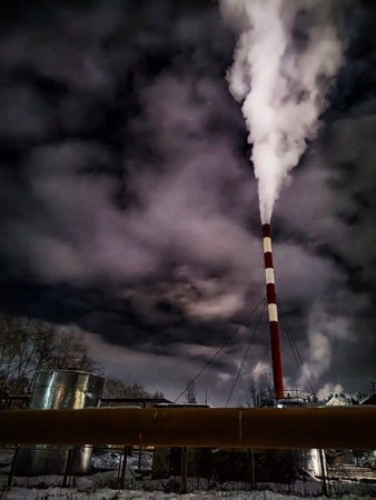 Winter night industrial landscape. Coal-fired power station with smoking chimneys against dramatic dark sky. Carbon dioxide CO2 emissions as primary driver of global climate change. Air pollutionの写真素材