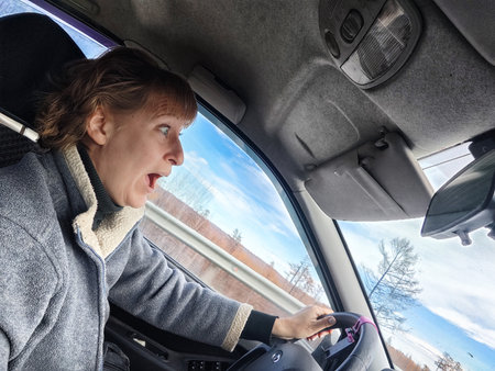 Terrified female driver a second before the accident. Scared middle-aged adult woman holds the...