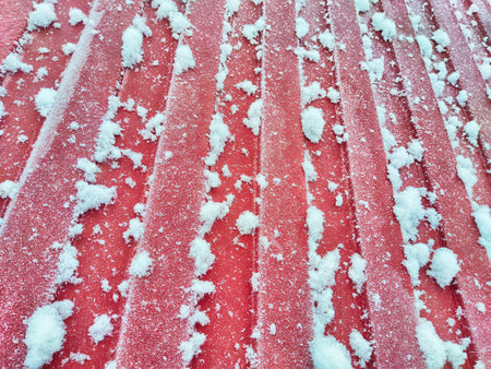 Fence made of galvanized corrugated board in the snow In the village after a snowfall. Abstract background, pattern, texture, place for text and copy spaceの写真素材