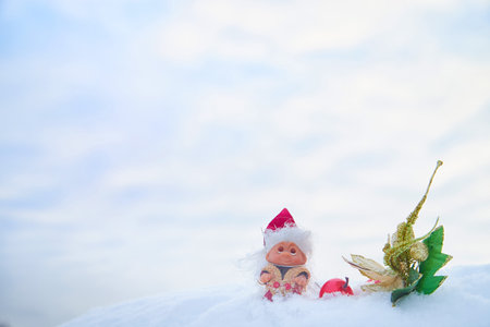 Cute little funny dwarf And a shiny twig in the snow in the landscape in winter. Wizard on a snowy background. Christmas and New Yearの写真素材
