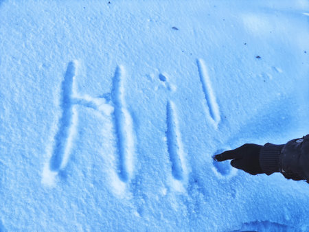 Inscription Hi, written on white background of the snow. Top view. Flat lay. New year and Christmas. Greeting morning, day, weather, sun and peopleの写真素材