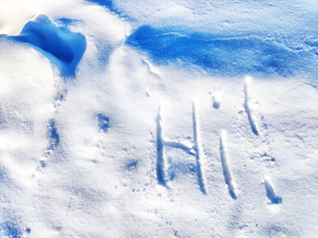Inscription Hi, written on white background of the snow. Top view. Flat lay. New year and Christmas. Greeting morning, day, weather, sun and peopleの写真素材
