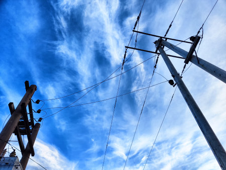 Old power poles and the sky with clouds in the background. Electric lines, towers, wires in landscapeの写真素材