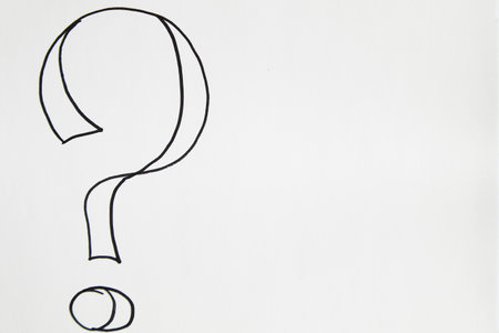 Hand-drawn question mark, boldly marked in black on white sheet of paper, symbolizing the concept of questioning, uncertainty, and the search for informationの写真素材