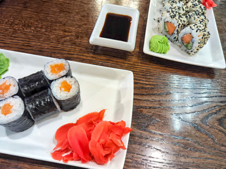 Sushi rolls with fresh ingredients served on platter. Japanese Sushi Rolls on White Plate With Ginger Garnish. Blurred and Partial focusの写真素材