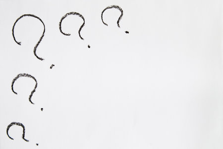 Hand-drawn question mark, boldly marked in black on white sheet of paper, symbolizing the concept of questioning, uncertainty, and the search for informationの写真素材