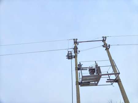 Old power line pole and transformer against blue sky in a nice sunny day