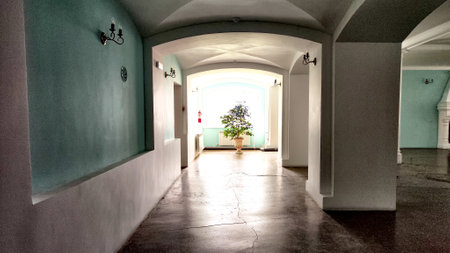 Sunlit Arched Hallway With Colonial Architecture. Bright courtyard seen through an archway with...