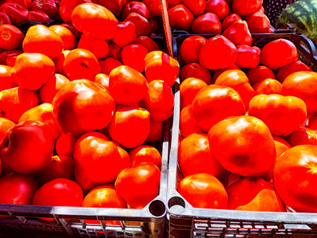Close-up of a large pile of bright red, ripe tomatoes for sale at local market. Background, texture, pattern, frame, copy spaceの写真素材