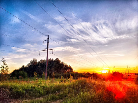 Old pole with wires against the sky. Electric transmission line, Eco-friendly energy at sunset