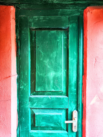 A bright green door is positioned upright and features a small light fixture mounted on top of it, adding an attractive touchの写真素材