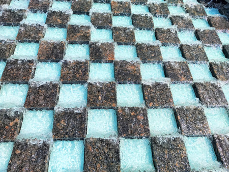 The old stone floor is covered with water drops. Water fountain.