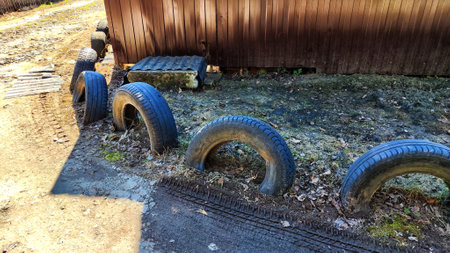 Old tires used as drainage pipes along a rural property in early springの写真素材