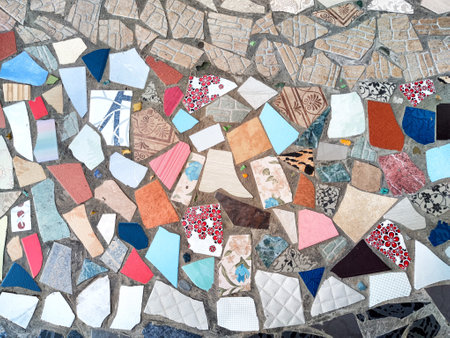 A decorative mosaic made of diverse tile pieces featuring an array of colors and patterns creates a...