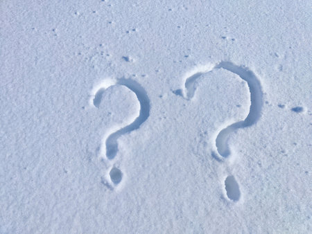A clear question mark carved into untouched snow under bright sunlight.の写真素材