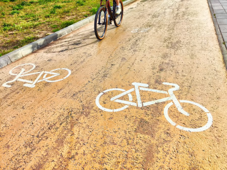 A clear, bright white bicycle symbol has been painted onto a textured pavement surface to enhance visibilityの写真素材
