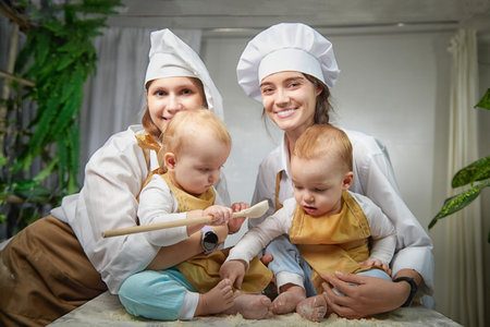 A families enjoys a fun cooking session, playfully covered in flour while engaging with little ones in a warm kitchen. Mothers and children having funの写真素材