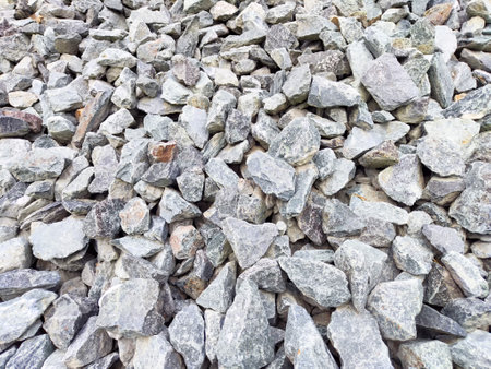 This textured surface of gray stone gravel creates a versatile backdrop perfect for various design...